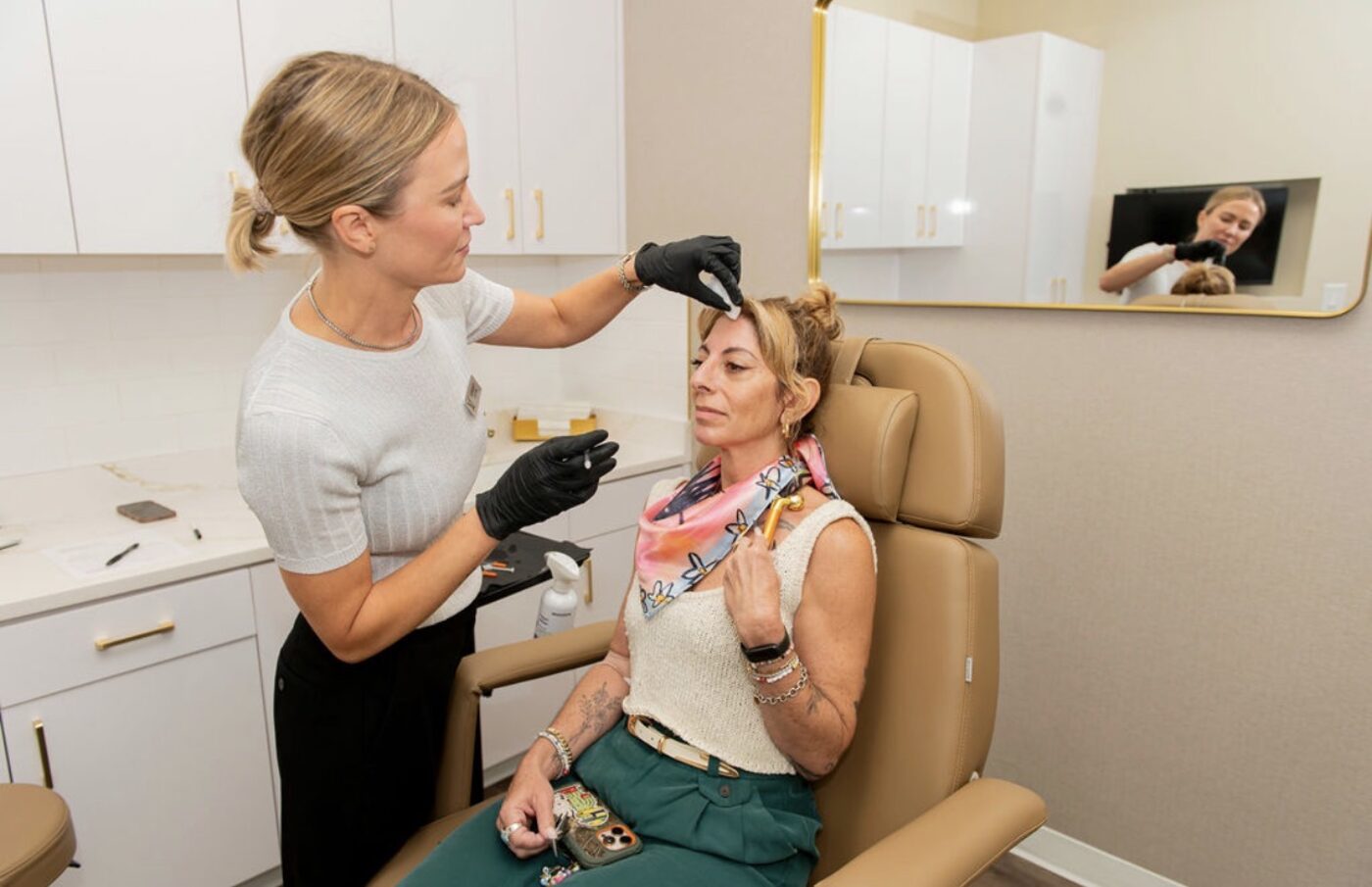 Lindsey Strelecki, BSN, RN, injecting a neuromodulator near a patient’s brow in a treatment room at Manor in Fort Worth